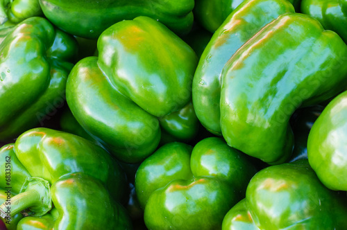 Green bell peppers on display at the market
