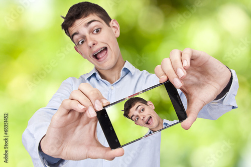 Young boy with phone becoming a self-portrait