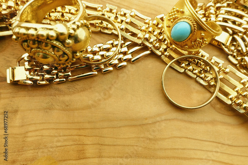 Gold jewelry with copy space on wood background