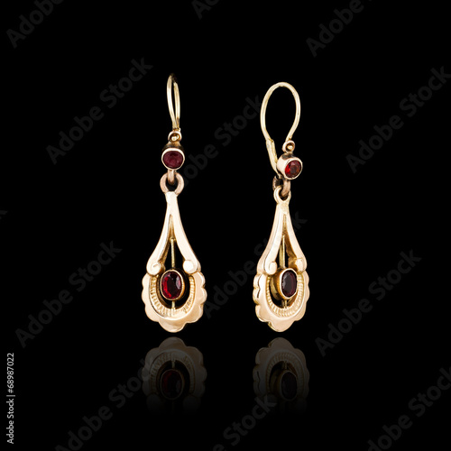 Gold earrings isolated on black background