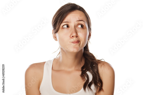 confused young woman posing on a white background