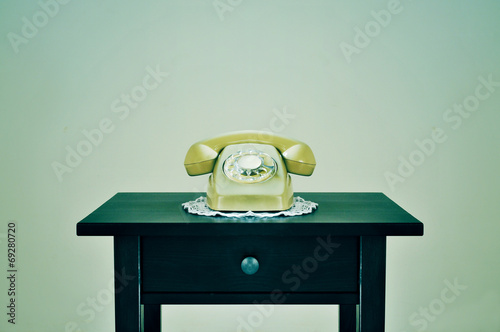 old rotary dial telephone on a table, with a retro effect