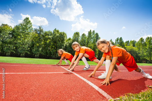 Children on bending knees in row ready to run
