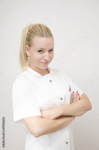 Young blonde nurse with crossed arms