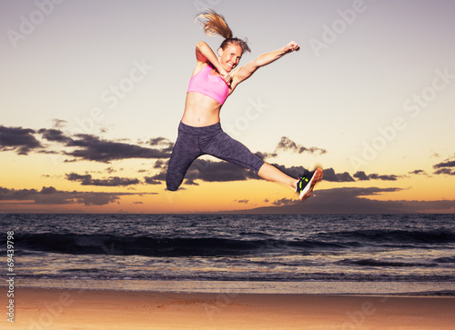 Woman jumping on the beach at sunset