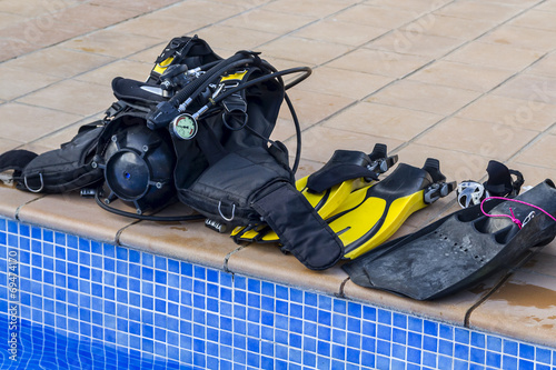 Scuba diving equipment on the edge of a pool