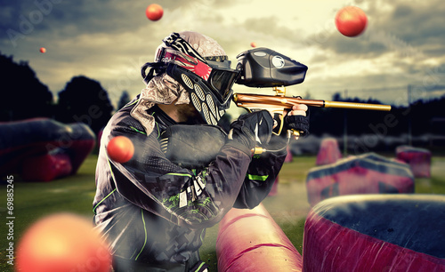 Paintball player in mid game being shot at