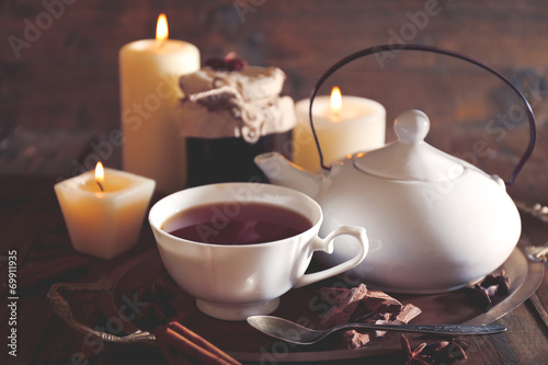 Composition with tea in cup and teapot and candles