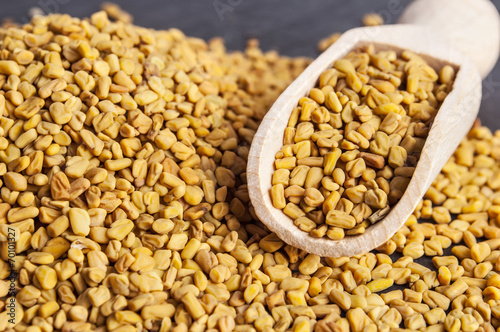 wooden scoop with fenugreek seeds