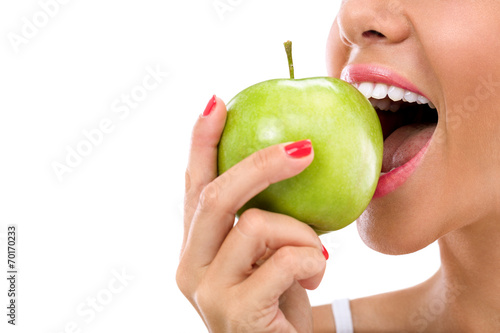 woman biting a green apple