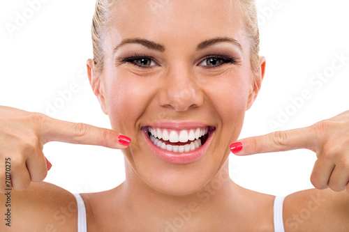 Smiling woman pointing in her perfect teeth