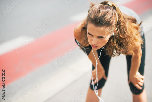 Portrait of tired fitness young woman outdoors in the city 