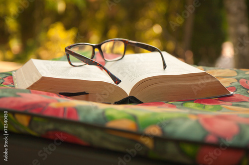Książka z okularami leży na kolorowym materacu