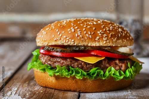 hamburger with cutlet grilled on a wooden surface