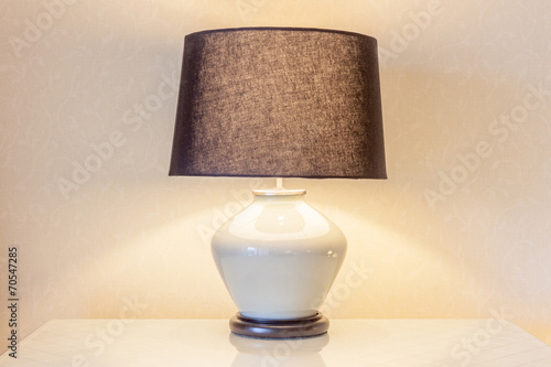 Table lamp and its shadow on wallpaper in the bedroom