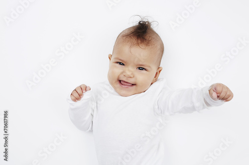 Cheeky baby girl with mohican hairstyle in baby gro.