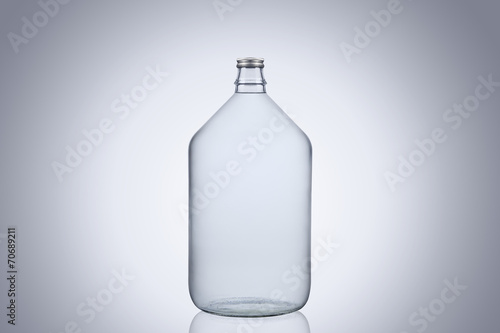 Big glass water bottle demijohn isolated on white background