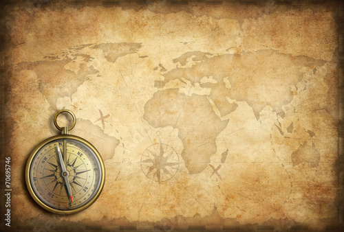 old brass or golden compass with world map background