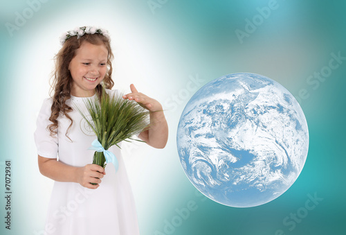 Dziewczynka w białym wianku z bukietem zboża.