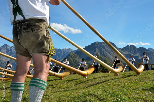 Alphornspieler mit Tracht im Gebirge