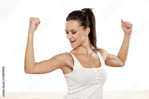 Happy attractive girl showing her biceps