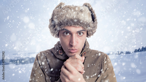 Portrait of young man with eskimo hat and winter background wit