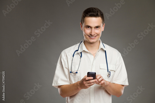 Smiling doctor posing with mobile phone