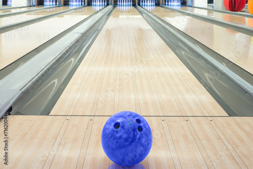 Balls on bowling alley against ten pins