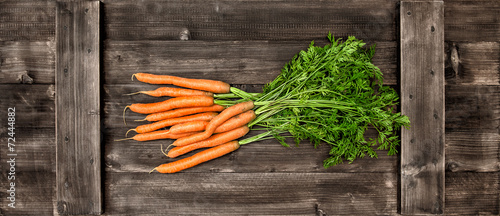 Fresh carrots over wooden background. Vegetable. Food