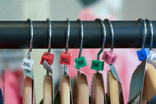 Hangers with clothes and sizes on rail