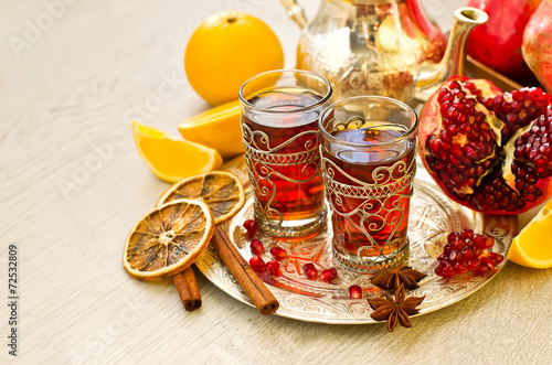 Traditional arabic tea with metal teapot pomegranate and spices
