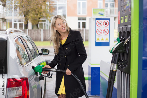 Woman refilling car with fuel