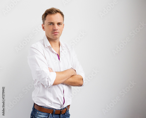 Young creative man standing with arms crossed