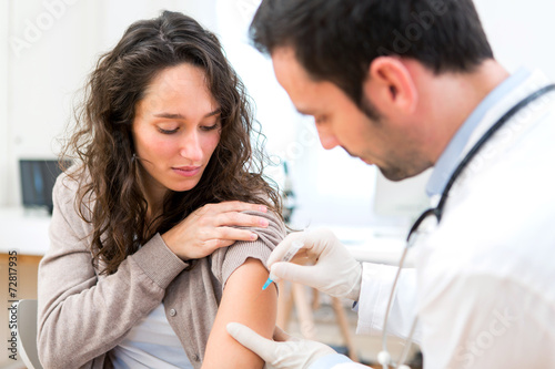 Young attractive woman being vaccinated