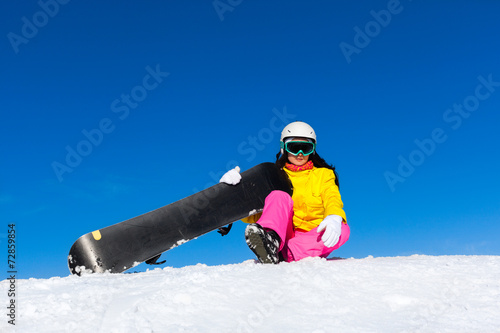 snowboarder woman sitting on snow mountain slope