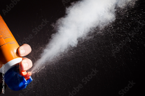 A spray of liquid and gaz from a can of compressed air