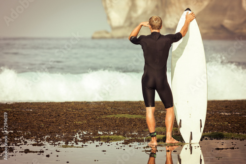 Surfer with surfboard on a coastline