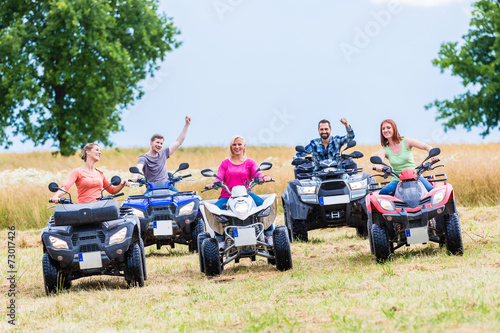 Friends driving off-road with quad bike or ATV