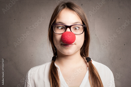 happy young girl with a clown nose