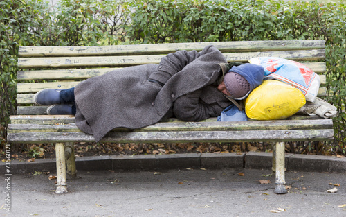 Homeless man sleeping on a bench