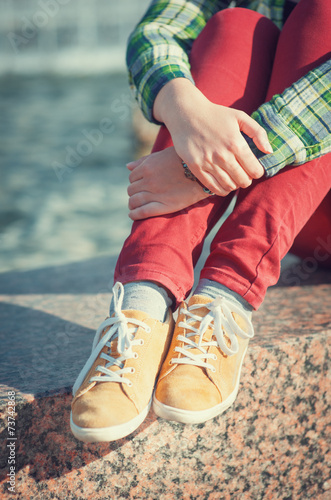 Yellow sneakers on girl legs in hipster style