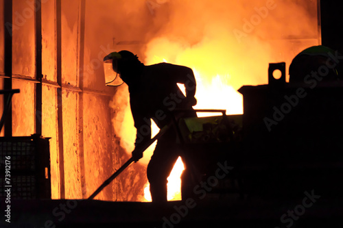 Man is working in the splashing molten iron - Stock Image