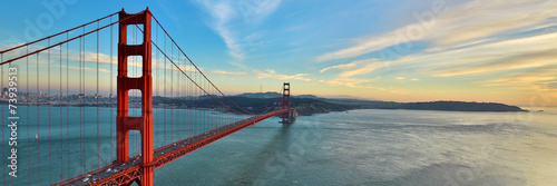Golden Gate Bridge panorama, San Francisco California, sunset light on cloudy sky 
