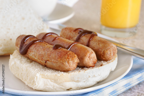 Sausage sandwich or breakfast roll drizzled with brown sauce