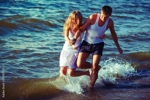 Happy couple running on the beach