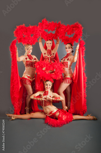 four young beautiful girls dancers in red dresses posing in stud