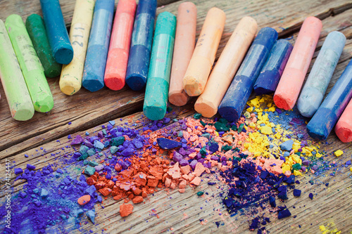 Collection of rainbow colored pastel crayons with pigment dust.