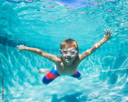 Young Boy Diving Underwater in Swimming Pool