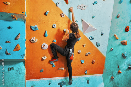 Woman climbing up on practice wall