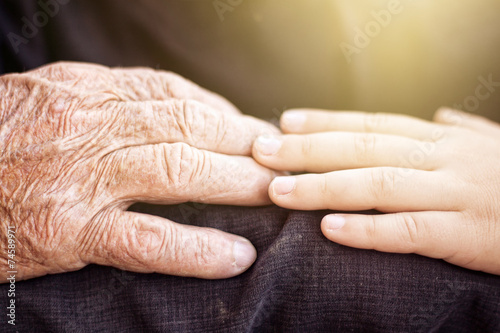 nephew touching grandfather's hand